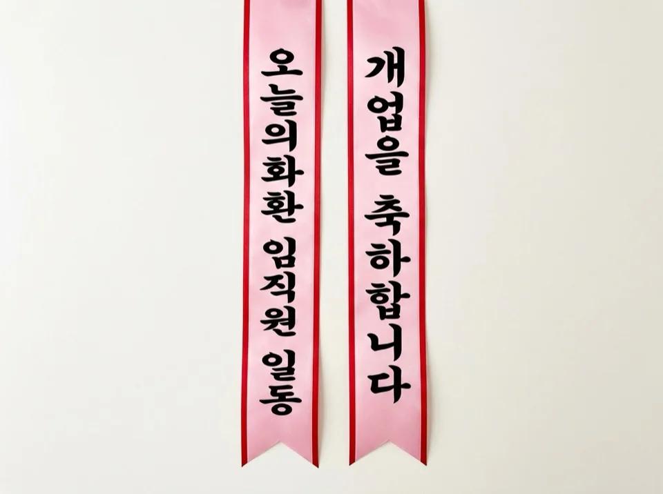 왼쪽 리본에는 보내는 분, 오른쪽 리본에는 축하 문구가 세로로 새겨진 두 줄의 리본